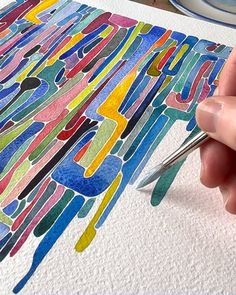 a person is drawing with colored pencils and watercolor paints on paper that has been drawn