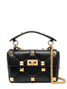 medium Roman Stud tote bag from VALENTINO GARAVANI featuring black, calf leather, gold-tone hardware, signature Roman Stud detailing, chain-link shoulder strap, single flat top handle and internal zip-fastening pocket. Designer Black Flap Bag With Turn-lock Closure, Designer Flap Bag With Turn-lock Closure And Top Handle, Designer Black Quilted Flap Bag, Designer Quilted Black Flap Bag, Designer Black Bag With Turn-lock Closure, Designer Shoulder Bag With Chain Strap And Top Handle, Designer Top Handle Shoulder Bag With Chain Strap, Shoulder Bag Black, Flats Top