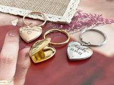 a person holding three different heart shaped key chains