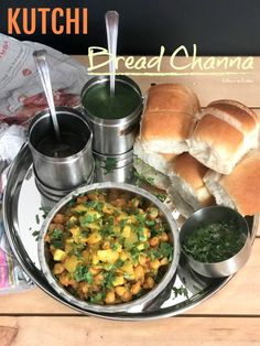 a silver plate topped with bread and bowls filled with food