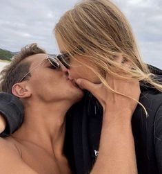 a man and woman kissing on the beach