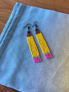 Looking Sharp! These fun and playful pencil earrings are made with high-quality seed beads and are guaranteed to bring a smile to your face. These are absolutely ADORABLE earrings and the pictures can't possibly capture their cuteness.  These would make the perfect gift for your favorite Teacher, a new teacher, an author. Well, anyone really, because I'm none of these and I'm wearing them simply because they make me happy! Don't forget Teacher Appreciation Week is coming up! Crafted with comfort in mind, these earrings are incredibly lightweight so you can wear them all day long These adorable earrings dangles from a hypo-allergenic earwire allowing for a lot of movement.  Approximately 3  inches in length, hanging one 3.5 inches off the earlobe. Please Note: We do our best to capture the Girls Fringe, Pencil Earrings, New Teacher, Favorite Teacher, Teacher Appreciation Gift, Teacher Appreciation Week, New Teachers, Teacher Favorite Things, Fringe Earrings