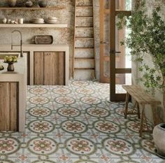 a kitchen with an old brick wall and tiled flooring, along with potted plants