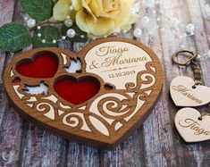 two heart shaped wooden keychains sitting next to each other on top of a table