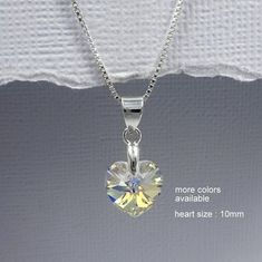 Genuine Swarovski  10 mm AB crystal heart pendant on sterling silver necklace chain. AVAILABLE IN OTHER COLORS: Please see color chart for options and kindly note your preference on check-out Necklace default length: 14 inches. For other lengths, please select from drop down list. MORE FLOWER GIRL JEWELRY: https://www.etsy.com/shop/alexandreasjewels?section_id=10012190&ref=shopsection_leftnav_8 COMES CAREFULLY AND BEAUTIFULLY GIFT PACKAGED.  MORE FROM ALEXANDREASJEWELS: https://www.etsy.com/shop Swarovski Heart Necklace, Swarovski Pearl Necklace, Flower Girl Necklace, Bridesmaid Necklace Gift, Flower Girl Jewelry, Silver Necklace Chain, Birthday Necklace Gift, Swarovski Heart, Cube Necklace