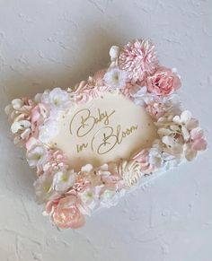 there is a cake that has been decorated with flowers and the words baby in bloom on it