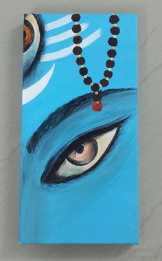 a painting of an eye with beads hanging from it's side on a wall