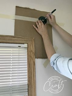 a person is painting the wall with brown paint