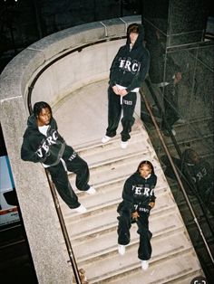 three young men are sitting on the steps