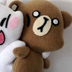 two brown and white stuffed animals sitting next to each other