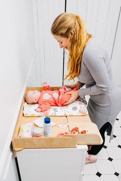 a woman is playing with her baby in the crib while another child looks on