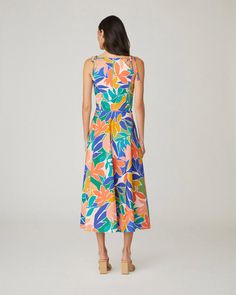 Floral printed cotton sleeveless midi sundress. This style features shoulder ties, a curved neckline, a fitted bodice with interior boning, and a full A-line midi skirt with side seam pockets. Bodice lined, skirt unlined. Hidden back zipper. 97% Cotton, 3% Spandex. Dry clean only. Color: Sunburst Multi Spring A-line Midi Dress With Tie Straps, A-line Sundress With Tie Straps, Vacation A-line Midi Dress With Tie Back, Printed A-line Midi Dress For Garden Party, Sleeveless Multicolor Tropical Print Midi Dress, Summer Midi Dress With Tropical Print, Sleeveless Multicolor Midi Dress With Tropical Print, Lined Sleeveless Sundress Midi Length, Lined Sleeveless Midi Sundress