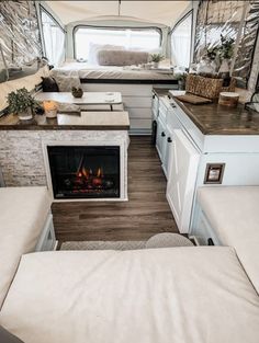 the inside of a camper with a fireplace and couch