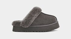 UGG Women's Disquette Slipper Merging the Coquette and Disco styles for a new slipper that's completely unique, the Disquette adds a retro-style platform sole to a familiar slip-on silhouette for outdoor wear, all-day cushion, and a maximalist look. Crafted from our signature sheepskin and suede, this effortless style adds a playful statement to all your favorite outfits try pairing with jeans or a flowy midi dress. Suede upper Sheepskin collar 10mm sheepskin lining 10mm sheepskin insole EVA out Grey Ugg, Disco Style, Flowy Midi Dress, Dr Shoes, Sheepskin Slippers, Ugg Slippers, Platform Slippers, Aesthetic Shoes, Dream Apartment