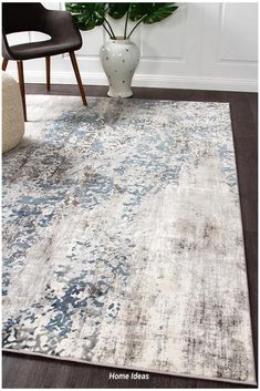 a white and blue area rug in a living room with a plant on the floor