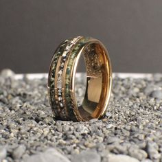 two gold rings with different colored stones on the ground