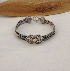 Simultaneously strong and delicate, a band in 4 strands of fine silver woven work encircles the wrist. A beautiful double heart motif carved with flowers sits centrally and is replicated at the closure. Moroccan handmade.  This bracelet is a great addition for everyday wear. Suits larger wrist size.  Weight : 29.5 Silver: stamped 925 Shipping : DHL EXPRESS 🙂 Classic Ceremonial Bracelet With Intricate Design, Adjustable Sterling Silver Bangle With Intricate Design, Adjustable Intricate Sterling Silver Bangle Bracelet, Elegant Engraved Braided Bangle Bracelet, Classic Adjustable Bracelet With Intricate Design, Adjustable Sterling Silver Bracelet With Intricate Design For Anniversary, Elegant Adjustable Sterling Silver Bracelet With Oxidized Finish, Handmade Silver Promise Bracelets, Traditional Engraved Sterling Silver Braided Bracelets