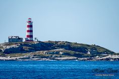 a red and white lighthouse sitting on top of a hill