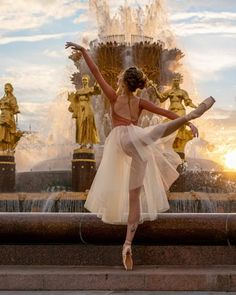 a ballerina is dancing in front of a fountain