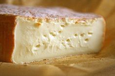 a piece of cheese sitting on top of a wooden table