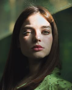 a woman with long brown hair and green shirt