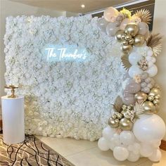 a white and gold wedding backdrop with flowers, balloons and the words the tenders on it