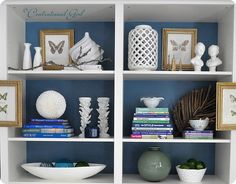 a white book shelf filled with different types of vases and other decorative items on top of it