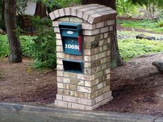 a brick mailbox sitting next to a tree