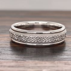 this is an image of a wedding ring on a wooden table with wood flooring