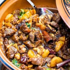 a bowl filled with meat and vegetables on top of a table