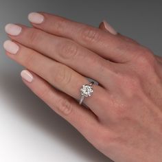 a woman's hand with a diamond ring on it