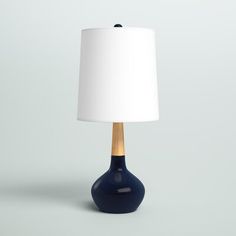 a blue table lamp with a white shade on the base and a wooden stick sticking out of it