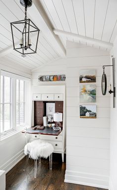 a white desk and chair in a room with wood flooring on one side and wooden ceilings on the other