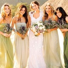 a group of women standing next to each other wearing dresses and holding bouquets in their hands