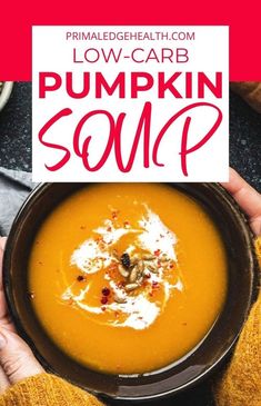 a person holding a bowl of pumpkin soup with the words low carb pumpkin soup