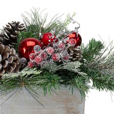 a wooden box filled with christmas decorations and pine cones