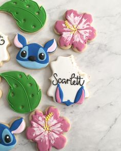 some decorated cookies are on a white table with pink and blue flowers in the middle