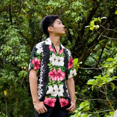 a man standing in front of trees looking up at the sky with his eyes closed