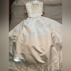 a white dress is laying on a bed