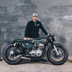 a man standing next to a parked motorcycle