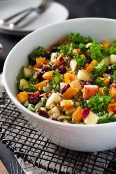 a white bowl filled with lots of food on top of a metal grate table