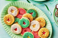 a green plate topped with lots of donuts covered in frosting and sprinkles