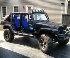 a black jeep with blue seats parked in front of a house