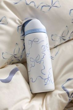 a white and blue water bottle sitting on top of a bed