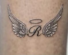 an angel wing tattoo with the letter r on it