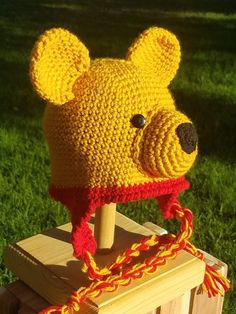 a crocheted bear hat on top of a wooden post