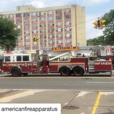 a fire truck is parked on the side of the road in front of a tall building