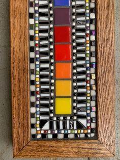 a wooden frame holding a multicolored glass mosaic