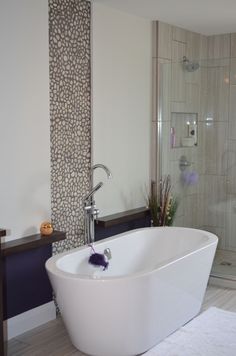 White Freestanding Tub with Chrome Fixtures
In this transitional bathroom, a white freestanding tub takes center stage, creating a focal point in the space. Pebble Tile Bathroom, White Freestanding Tub, Pebble Shower Floor, Pebble Tiles, Bathroom Natural, Iridescent Glass Tiles, Pebble Floor, Tiles For Bathroom, Pebble Tile