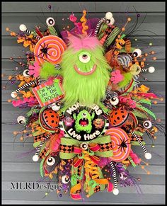 a green stuffed animal surrounded by lots of colorful decorations on the front of a house